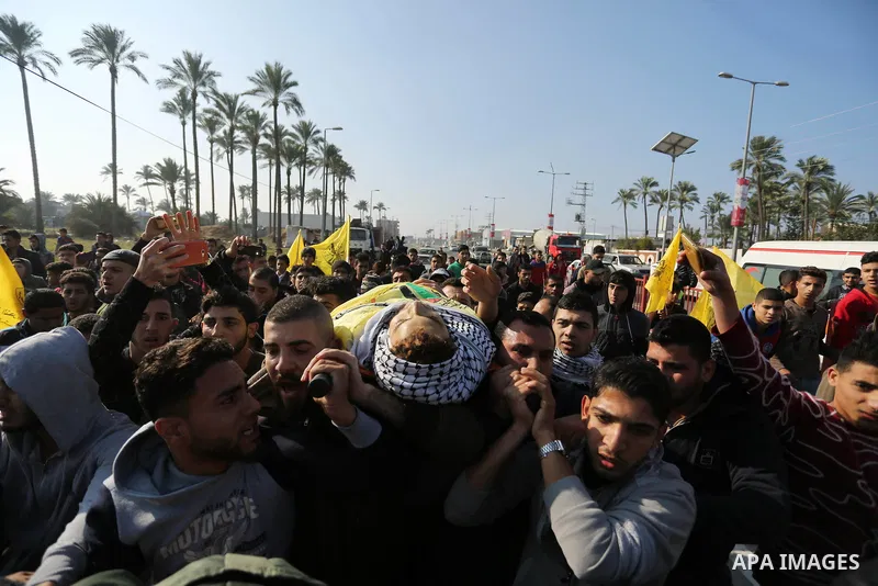 Mourners carry the body of Palestinian Jamal Mesleh, 21, who died of his injuries during clashes with Israeli security forces on Friday, during his funeral in the al-Maghazi refugee camp in the central Gaza Strip Decembe...