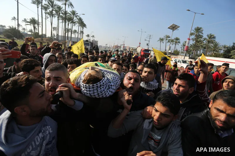 Mourners carry the body of Palestinian Jamal Mesleh, 21, who died of his injuries during clashes with Israeli security forces on Friday, during his funeral in the al-Maghazi refugee camp in the central Gaza Strip Decembe...