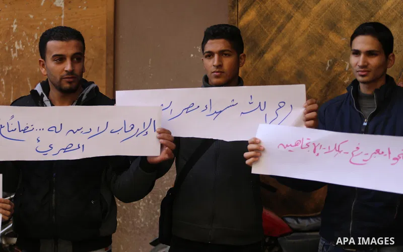 Palestinian youths hold banners during a protest demanding to open the Rafah crossing, in Gaza city on December 31, 2017. Photo by Mohammed Asad