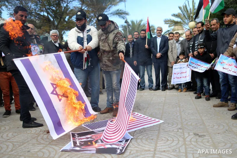 Palestinians attend burn an Israeli flag and a U.S. flag during a protest against U.S. President Donald Trump's decision to recognise Jerusalem as the capital of Israel, in Gaza City December 31, 2017. Photo by Yasser Qu...