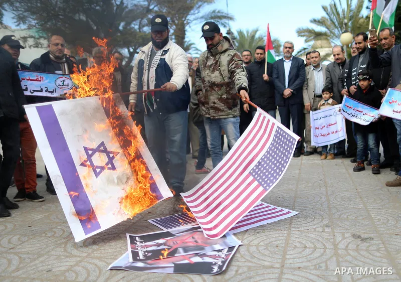 Palestinians attend burn an Israeli flag and a U.S. flag during a protest against U.S. President Donald Trump's decision to recognise Jerusalem as the capital of Israel, in Gaza City December 31, 2017. Photo by Yasser Qu...