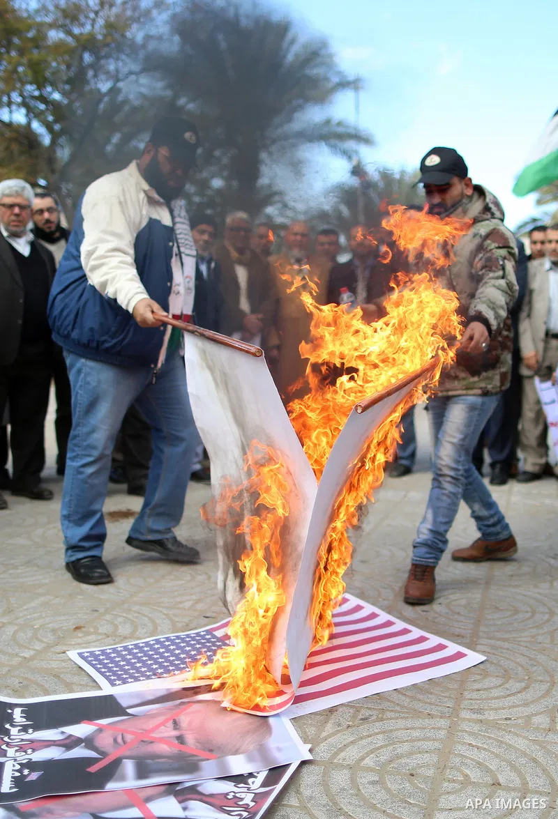Palestinians attend burn an Israeli flag and a U.S. flag during a protest against U.S. President Donald Trump's decision to recognise Jerusalem as the capital of Israel, in Gaza City December 31, 2017. Photo by Yasser Qu...