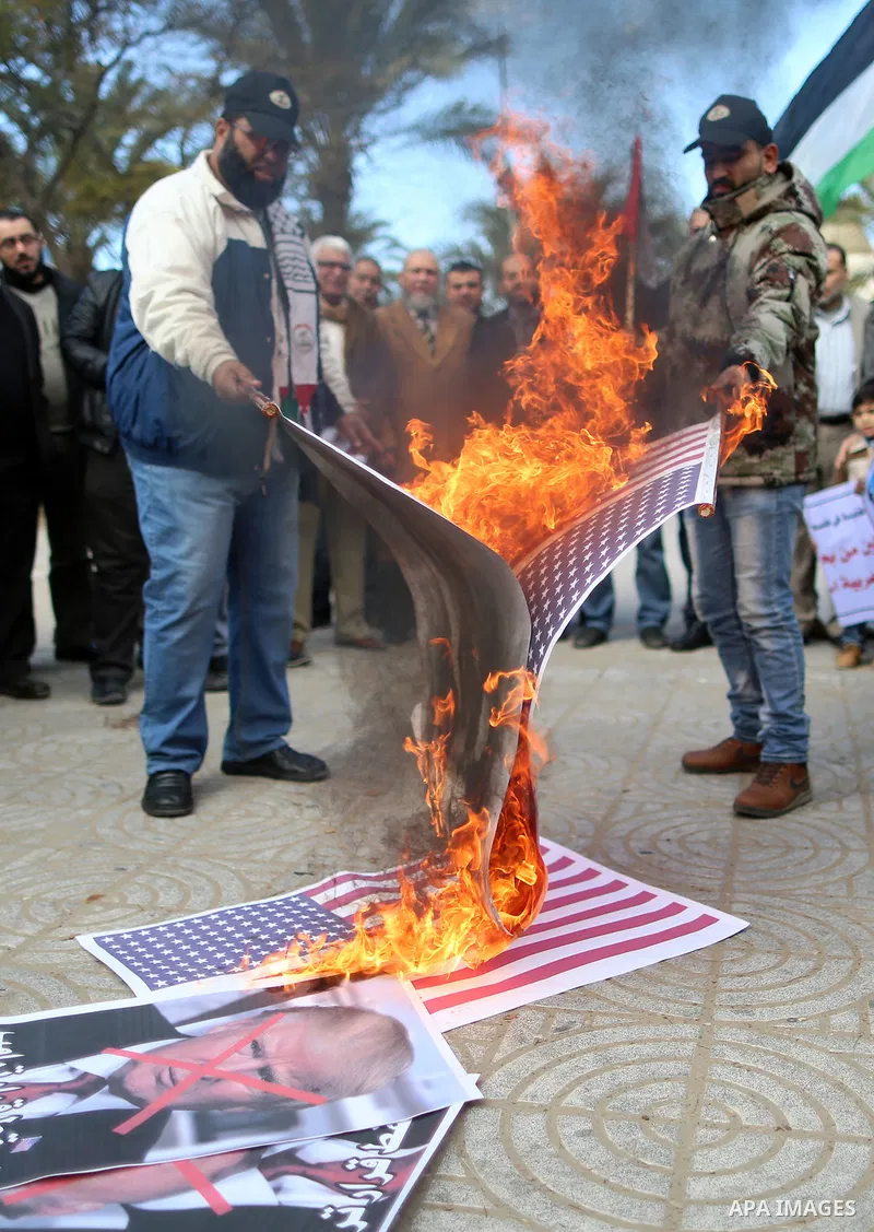 Palestinians attend burn an Israeli flag and a U.S. flag during a protest against U.S. President Donald Trump's decision to recognise Jerusalem as the capital of Israel, in Gaza City December 31, 2017. Photo by Yasser Qu...