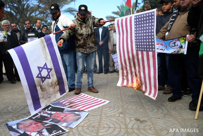 Palestinians attend burn an Israeli flag and a U.S. flag during a protest against U.S. President Donald Trump's decision to recognise Jerusalem as the capital of Israel, in Gaza City December 31, 2017. Photo by Yasser Qu...