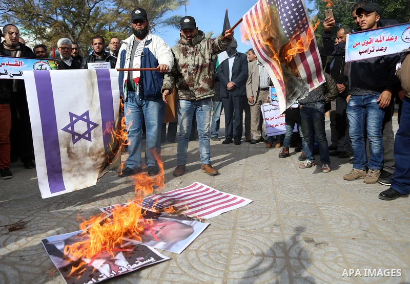 Palestinians attend burn an Israeli flag and a U.S. flag during a protest against U.S. President Donald Trump's decision to recognise Jerusalem as the capital of Israel, in Gaza City December 31, 2017. Photo by Yasser Qu...