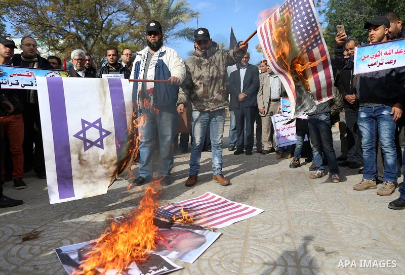 Palestinians attend burn an Israeli flag and a U.S. flag during a protest against U.S. President Donald Trump's decision to recognise Jerusalem as the capital of Israel, in Gaza City December 31, 2017. Photo by Yasser Qu...
