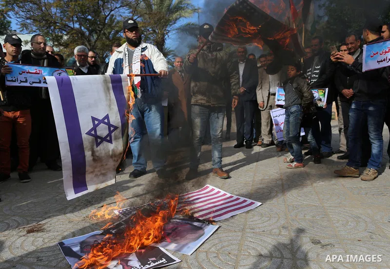 Palestinians attend burn an Israeli flag and a U.S. flag during a protest against U.S. President Donald Trump's decision to recognise Jerusalem as the capital of Israel, in Gaza City December 31, 2017. Photo by Yasser Qu...