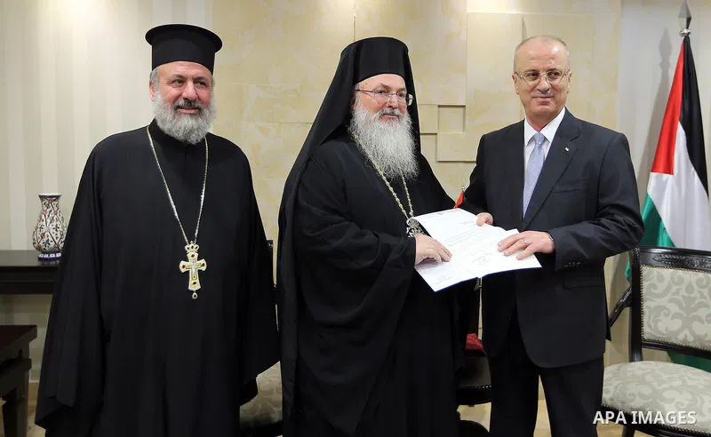 Palestinian Prime Minister, Rami Hamdallah, receives an invitation to attend the Midnight Mass for Christmas by the Eastern calendar, in the West Bank city of Ramallah, on December 31, 2017. Photo by Prime Minister Offic...