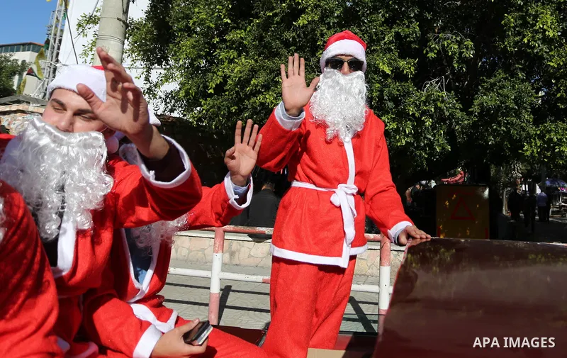 Palestinians dressed as Santa Claus ride a red car to welcome the new year, in the streets of Gaza City, New Year's Eve revellers on December 31, 2017. Photo by Ashraf Amra
