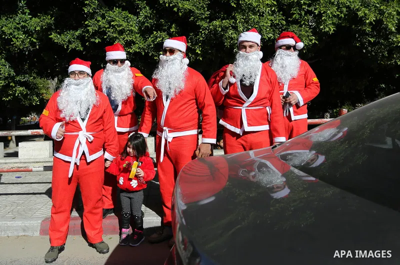 Palestinians dressed as Santa Claus celebrate to welcome the new year, in the streets of Gaza City, New Year's Eve revellers on December 31, 2017. Photo by Ashraf Amra