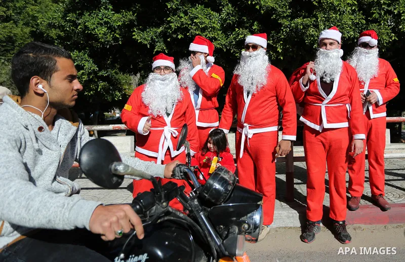 Palestinians dressed as Santa Claus celebrate to welcome the new year, in the streets of Gaza City, New Year's Eve revellers on December 31, 2017. Photo by Ashraf Amra
