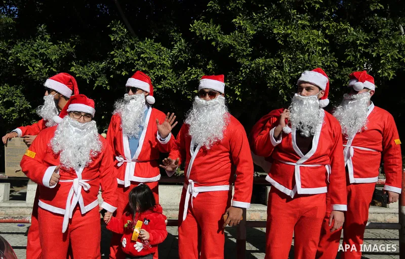Palestinians dressed as Santa Claus celebrate to welcome the new year, in the streets of Gaza City, New Year's Eve revellers on December 31, 2017. Photo by Ashraf Amra