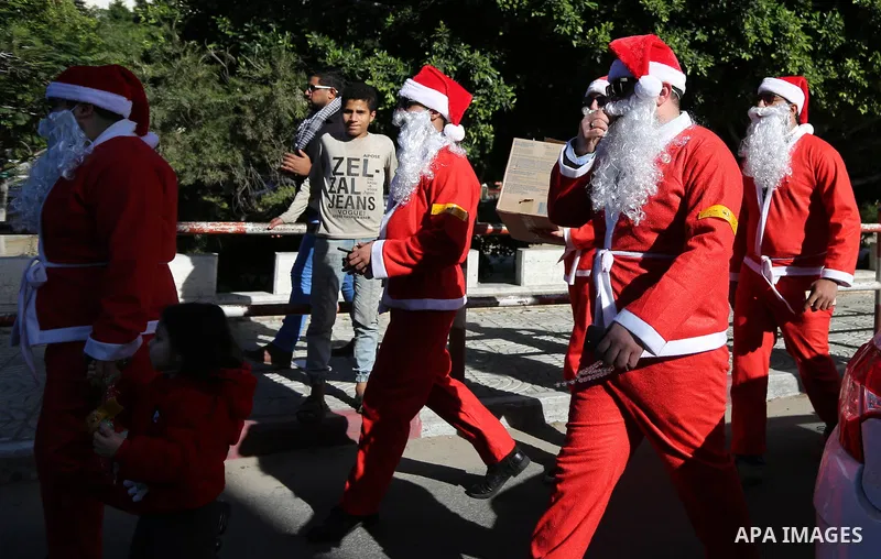 Palestinians dressed as Santa Claus celebrate to welcome the new year, in the streets of Gaza City, New Year's Eve revellers on December 31, 2017. Photo by Ashraf Amra