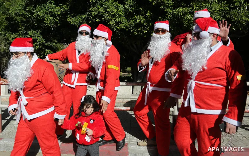 Palestinians dressed as Santa Claus celebrate to welcome the new year, in the streets of Gaza City, New Year's Eve revellers on December 31, 2017. Photo by Ashraf Amra