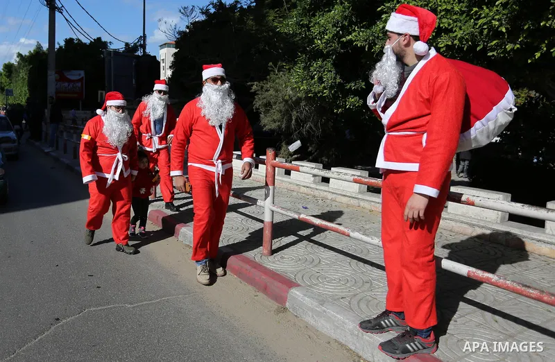 Palestinians dressed as Santa Claus celebrate to welcome the new year, in the streets of Gaza City, New Year's Eve revellers on December 31, 2017. Photo by Ashraf Amra