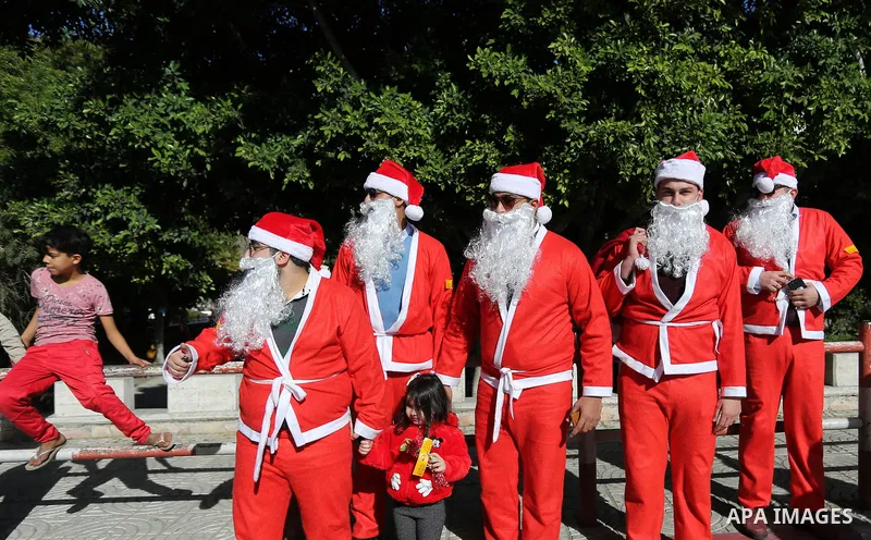 Palestinians dressed as Santa Claus celebrate to welcome the new year, in the streets of Gaza City, New Year's Eve revellers on December 31, 2017. Photo by Ashraf Amra