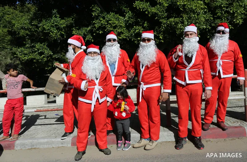 Palestinians dressed as Santa Claus celebrate to welcome the new year, in the streets of Gaza City, New Year's Eve revellers on December 31, 2017. Photo by Ashraf Amra