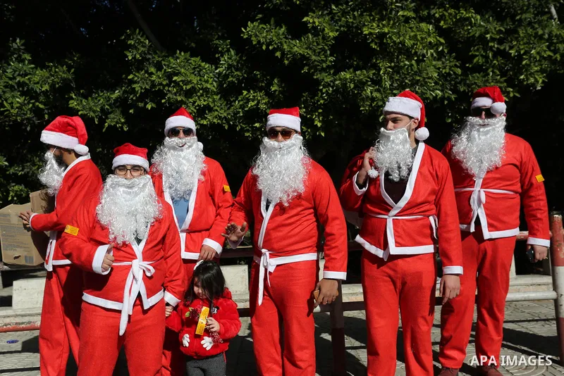 Palestinians dressed as Santa Claus celebrate to welcome the new year, in the streets of Gaza City, New Year's Eve revellers on December 31, 2017. Photo by Ashraf Amra