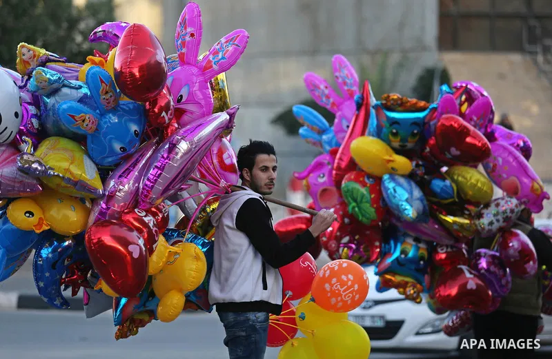 A Palestinian vendor sells ballons on the street in Gaza City on December 31, 2017 on the last day of the year. Photo by Ashraf Amra