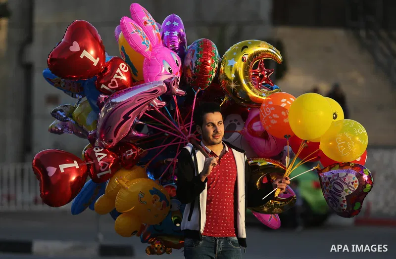 A Palestinian vendor sells ballons on the street in Gaza City on December 31, 2017 on the last day of the year. Photo by Ashraf Amra