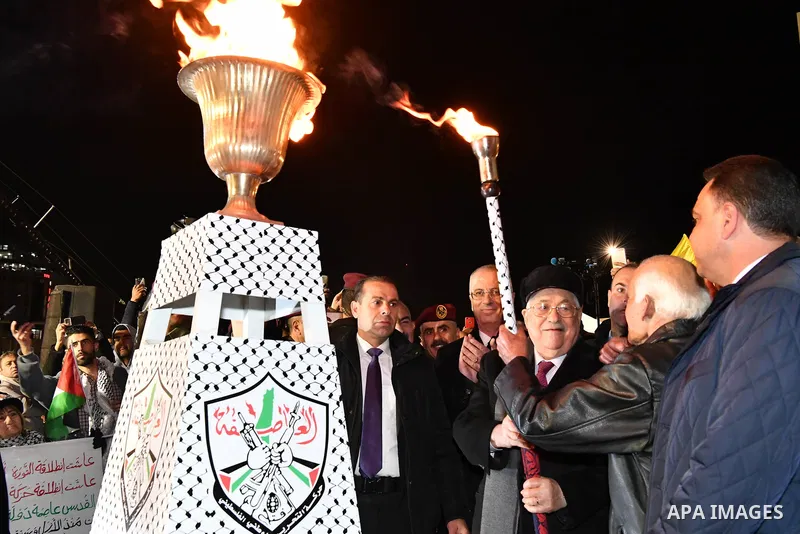 Palestinian president Mahmud Abbas lights an urn outside the tomb of the late President Yasser Arafat during a celebration marking the fifty-third anniversary of the creation of the Fatah movement in the West Bank city o...