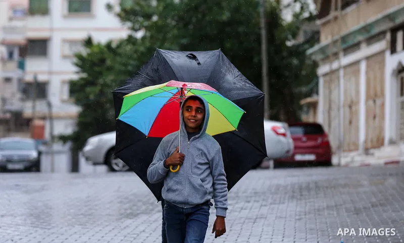 Palestinian children hold Umbrellas during a rainy day in Gaza city, on January 1, 2018. Photo by Yasser Qudih