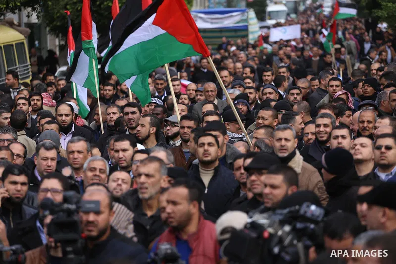 Palestinian employees of Gaza strip hold banners and Palestine flags during a demonstration demanding their rights, in Gaza city, on January 2, 2018. Photo by Mohammed Asad