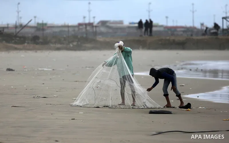 A Palestinian fisherman prepares his fishing nets on a beach in Gaza City on January 6, 2018. Photo by Ashraf Amra