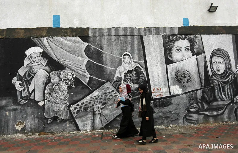 A Palestinian women walk past the headquarters United Nations Relief and Works Agency (UNRWA) in Gaza city on January 6, 2018. US envoy to the UN Haley warned US support for UNRWA would end if the PA refuses to enter neg...