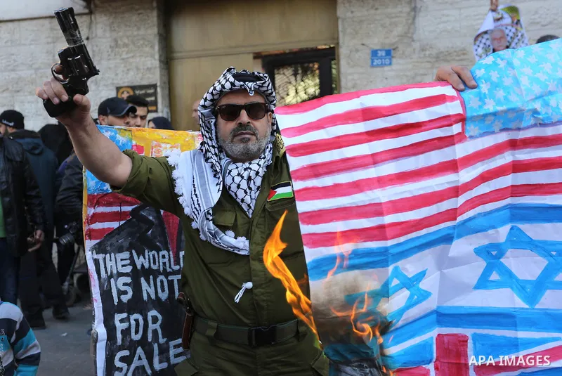 Palestinians burn an Israeli flag and a U.S. flag during a protest to show solidarity with Palestinian prisoners held in Israeli jails, in front of Red cross office in Gaza city, on January 8, 2018. Photo by Ashraf Amra