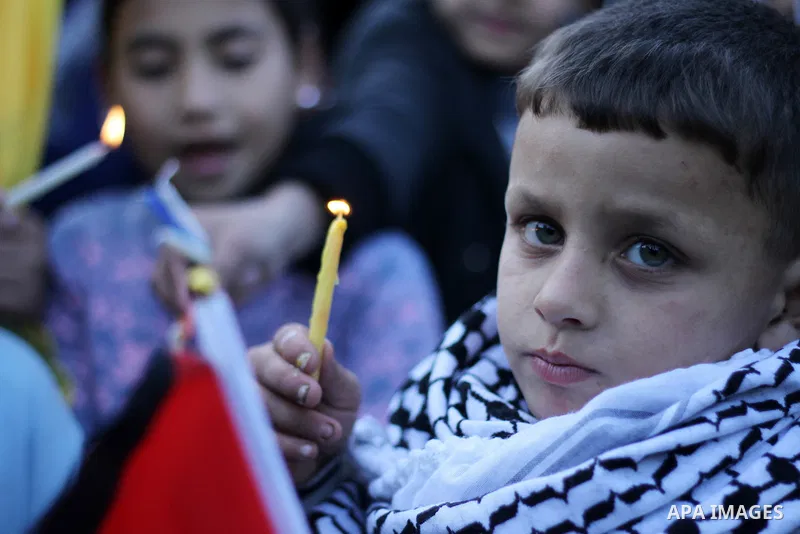 A Palestinian boy holds a candle during a protest in support of Palestinian teenager Ahed Tamimi, 16-year-old in Gaza city on January 8, 2018. Israel charged Tamimi with 12 counts including assault on January 1 following...