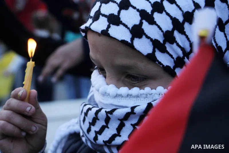 A Palestinian boy holds a candle during a protest in support of Palestinian teenager Ahed Tamimi, 16-year-old in Gaza city on January 8, 2018. Israel charged Tamimi with 12 counts including assault on January 1 following...
