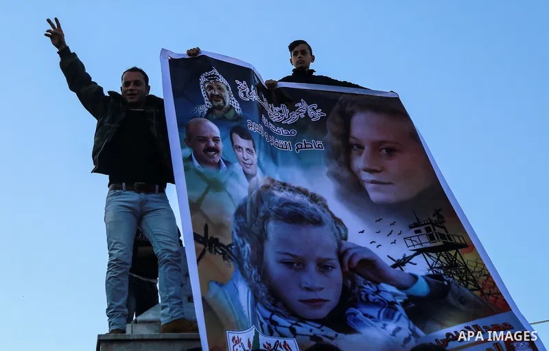 Palestinians hold a poster bearing the portrait of Palestinian teenager Ahed Tamimi, 16-year-old during a protest in her support in Gaza city on January 8, 2018. Israel charged Tamimi with 12 counts including assault on...
