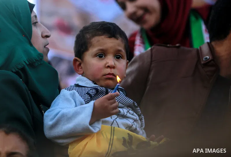 A Palestinian boy holds a candle during a protest in support of Palestinian teenager Ahed Tamimi, 16-year-old in Gaza city on January 8, 2018. Israel charged Tamimi with 12 counts including assault on January 1 following...