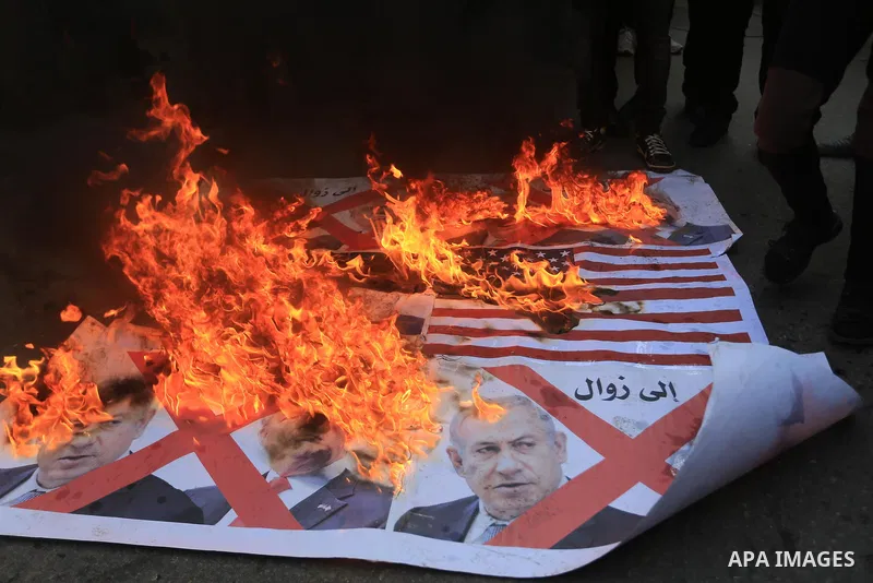 Palestinians burn posters of U.S. President Donald Trump's and Israeli President Benjamin Netanyahu during a protest against U.S. President Donald Trump's decision to recognise Jerusalem as the capital of Israel, in Gaza...