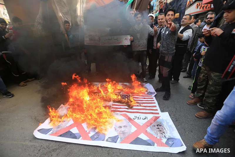Palestinians burn posters of U.S. President Donald Trump's and Israeli President Benjamin Netanyahu during a protest against U.S. President Donald Trump's decision to recognise Jerusalem as the capital of Israel, in Gaza...