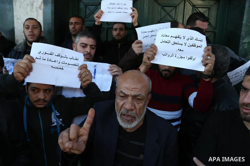 Palestinian employees of Gaza strip shout slogans during a protest demanding their salaries, in Gaza city, on January 11, 2018. Photo by Ashraf Amra