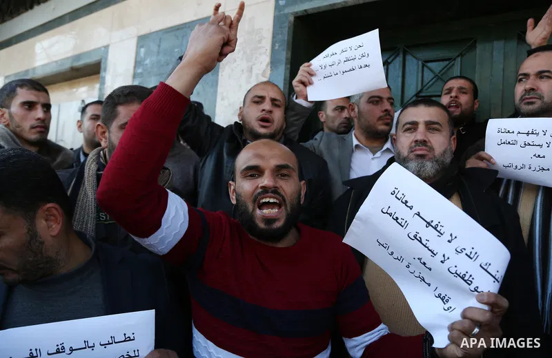 Palestinian employees of Gaza strip shout slogans during a protest demanding their salaries, in Gaza city, on January 11, 2018. Photo by Ashraf Amra