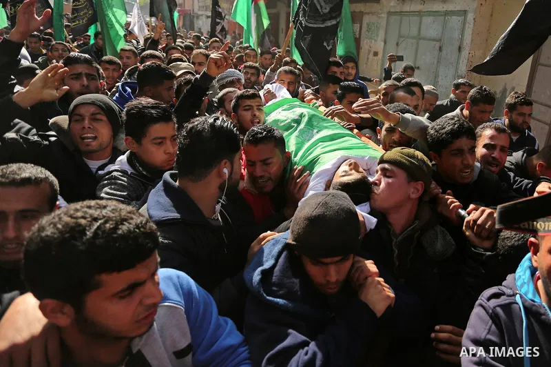 Palestinian mourners carry the body of Amir Abu Musaid, 16, during his funeral in the al-Maghazi refugee camp, in the centre of the Gaza Strip, after he was shot dead in clashes with the Israeli military along the Gaza b...