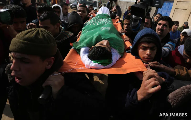 Palestinian mourners carry the body of Amir Abu Musaid, 16, during his funeral in the al-Maghazi refugee camp, in the centre of the Gaza Strip, after he was shot dead in clashes with the Israeli military along the Gaza b...