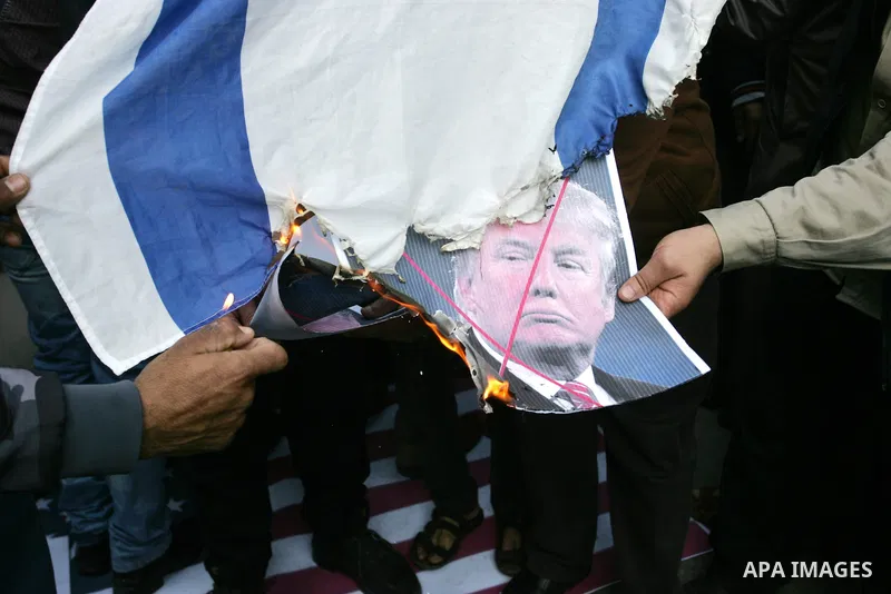 Palestinian supporters of the Islamic Jihad movement burn an Israeli flag and a portrait of US President Donald Trump during a protest against Trumps's decision to recognise Jerusalem as the capital of Israel, in the tow...
