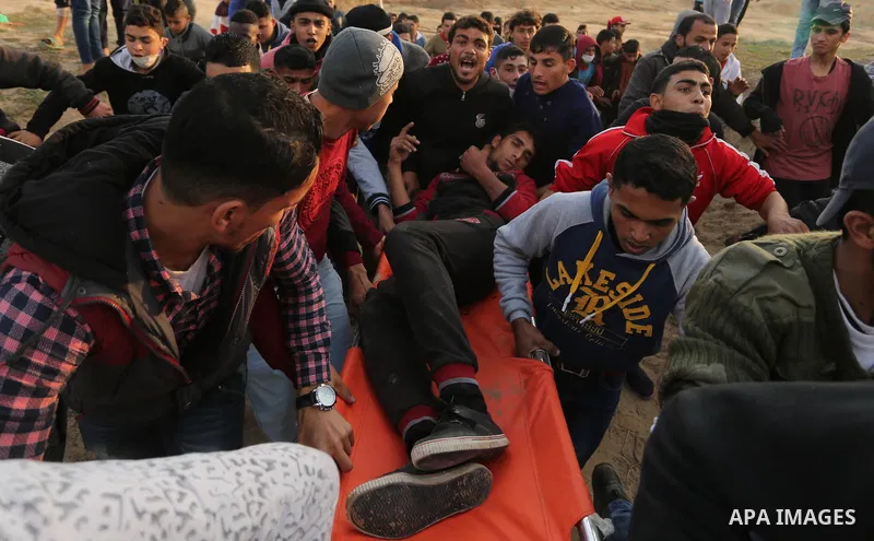 A wounded Palestinian protester is evacuated during clashes with Israeli security forces at the Bureij refugee camp, in central Gaza on January 12, 2018 as demonstrations continue over the US president's controversial re...