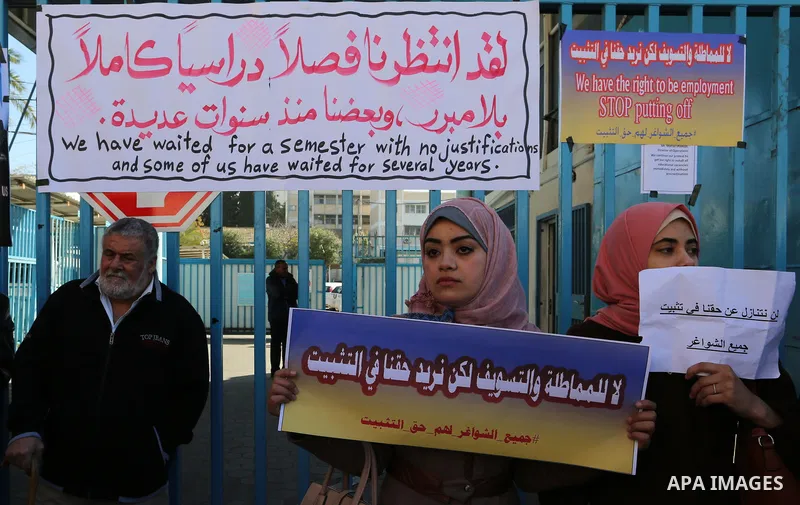 Palestinian teachers take part in a protest demanding their rights in front of the headquarters United Nations Relief and Works Agency (UNRWA), in Gaza City, on January 14, 2018. Photo by Yasser Qudih