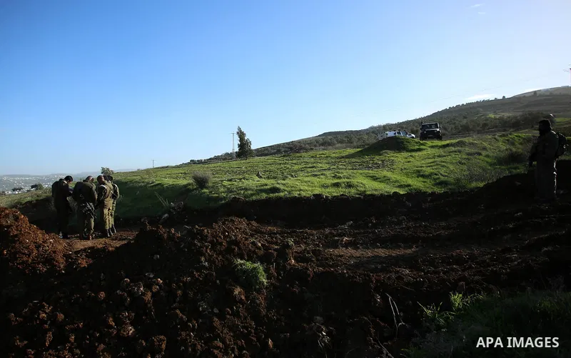 Israeli security forces stand guard during dredging Palestinian lands at the village of Burin near the West Bank city of Nablus, on January 14, 2018. Photo by Shadi Jarar'ah