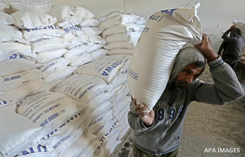 A Palestinian man carries sacks of flour at a United Nations food distribution center in Khan Younis in the southern Gaza Strip January 15, 2018. U.S. President Donald Trump is preparing to withhold tens of millions of d...
