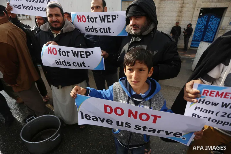 Palestinians hold banners during a protest against aid cut, in front of United Nations Development Programme office (UNDP), in Gaza City January 17, 2018. Photo by Mohammed Asad