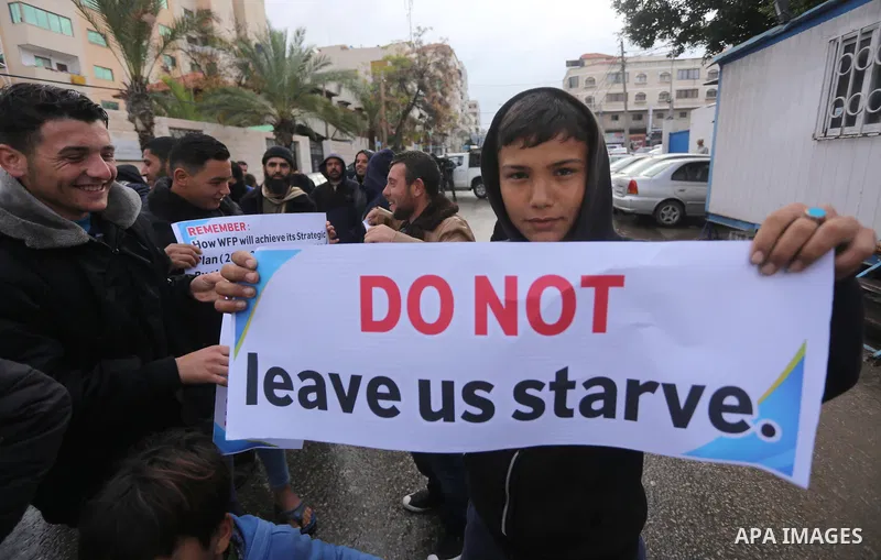 Palestinians hold banners during a protest against aid cut, in front of United Nations Development Programme office (UNDP), in Gaza City January 17, 2018. Photo by Mohammed Asad