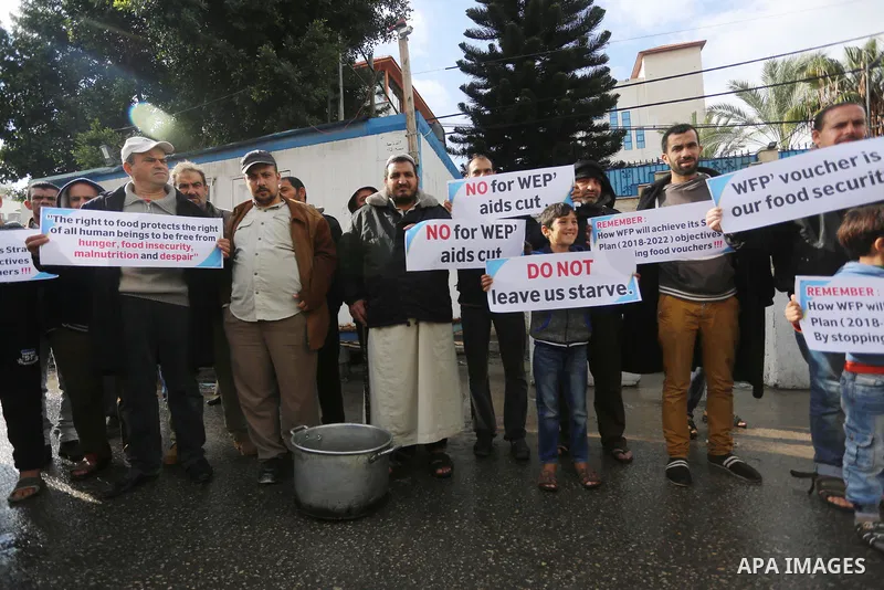 Palestinians hold banners during a protest against aid cut, in front of United Nations Development Programme office (UNDP), in Gaza City January 17, 2018. Photo by Mohammed Asad