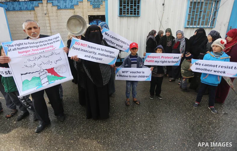 Palestinians hold banners during a protest against aid cut, in front of United Nations Development Programme office (UNDP), in Gaza City January 17, 2018. Photo by Mohammed Asad