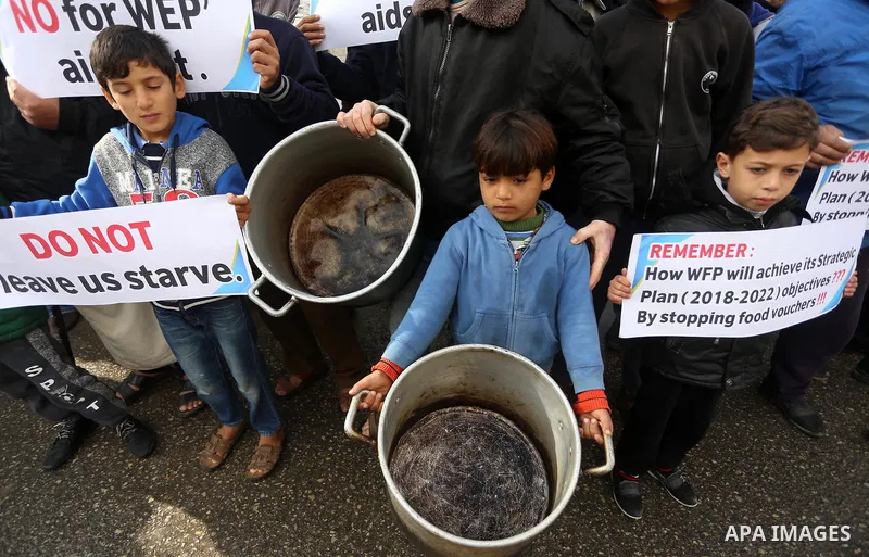 Palestinians hold banners during a protest against aid cut, in front of United Nations Development Programme office (UNDP), in Gaza City January 17, 2018. Photo by Mohammed Asad